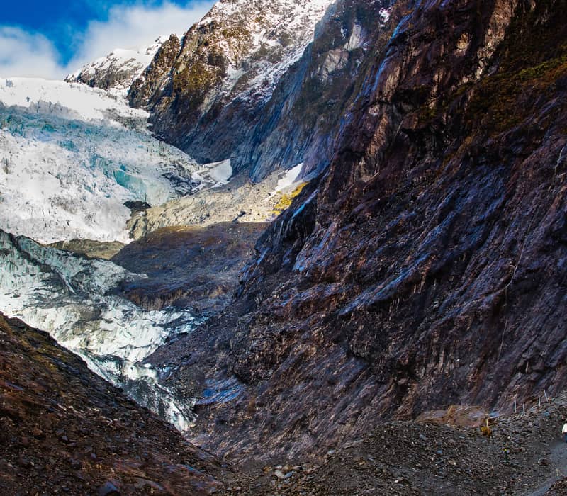 Aerial view of Franz Josef Glacier with mountains and clouds in New Zealand